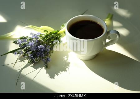 Cup of hot black coffee. Morning coffee with flowers. Romantic morning Stock Photo