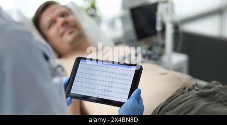 Female doctor hold in hand tablet pc with patient electrocardiogram Stock Photo