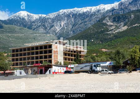 Tourist development construction building work view from Drymades beach to Mount Cika snow capped mountain range, Dhermi, Albanian Riviera, Albania Stock Photo