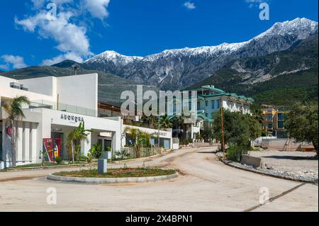 Tourist development construction building work view from Drymades beach to Mount Cika snow capped mountain range, Dhermi, Albanian Riviera, Albania Stock Photo