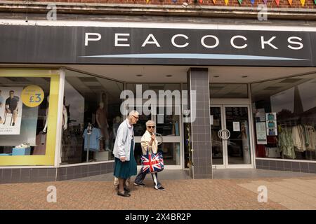 Two elderly ladies at the window display of PEACOCKS clothing chainstore in Leighton Buzzard, Bedfordshire, England, United Kingdom Stock Photo