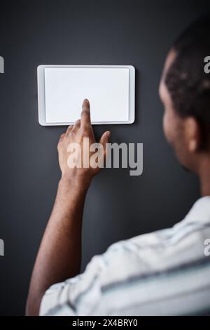 Vertical closeup of unrecognizable Black man tapping on home automation system control panel screen Stock Photo
