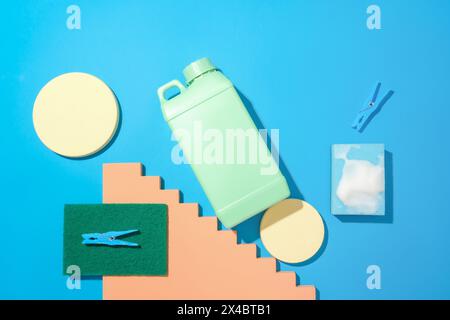 Round platforms, a bottle of detergent, a sponge and clothespins are placed on a blue background. Mockup of cleaning products for advertising. Flat la Stock Photo