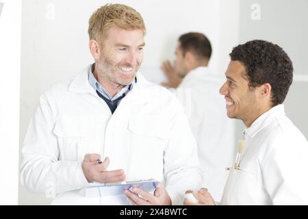instructor showing apprentices how to paint Stock Photo