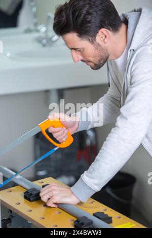 a plumber cutting plastic pipe Stock Photo