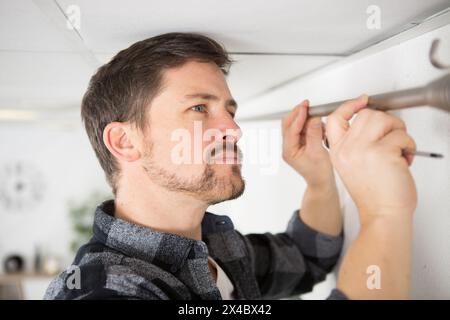 man mounting a curtain rail Stock Photo