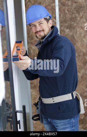 portrait of male builder using spirit level Stock Photo