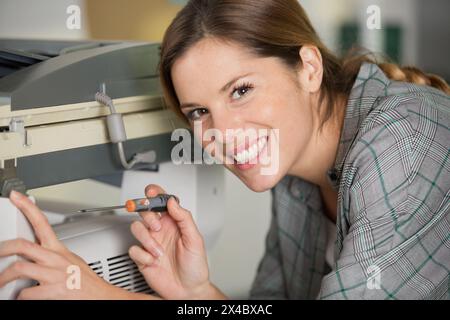 happy woman is fixing a printer Stock Photo