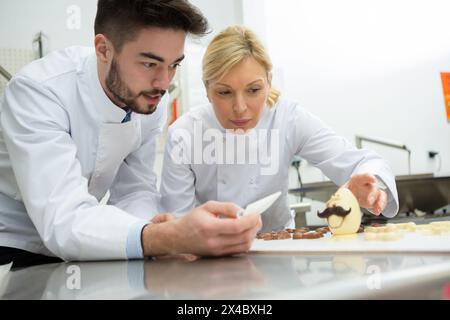 man and woman working on chocolate Stock Photo