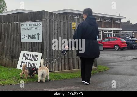 Rainham, UK. 02nd May, 2024. London Mayoral election. South Hornchurch Community hall. Rainham. A woman walks her 2 dogs into a polling station during the London Mayoral election 2024. Credit: Sport In Pictures/Alamy Live News Stock Photo