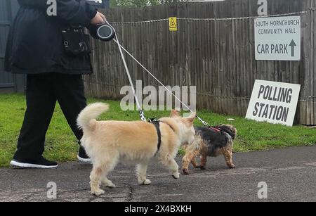 Rainham, UK. 02nd May, 2024. London Mayoral election. South Hornchurch Community hall. Rainham. A woman walks her 2 dogs into a polling station during the London Mayoral election 2024. Credit: Sport In Pictures/Alamy Live News Stock Photo