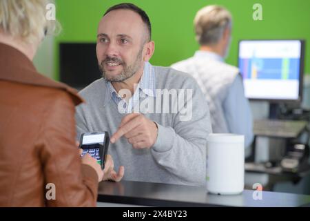 man paying bill through smartphone using nfc technology in cafe Stock Photo