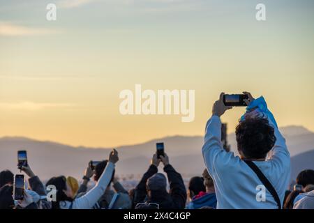 A crowd of tourists holding phones over their heads to take photos of the Florence skyline at Piazzale Michelangelo. An example of overtourism. Stock Photo