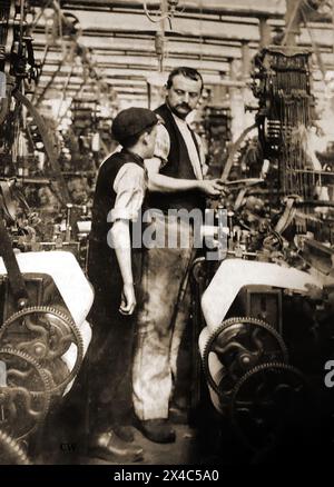 A British workman instructing an apprentice in a cotton mill c1900.j Stock Photo