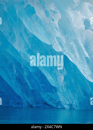 Iceberg in the fjord with melt structure. Landscape in the Johan Petersen Fjord, a branch of the Sermilik Icefjord, Ammassalik region, Greenland, Danish Territory. Stock Photo