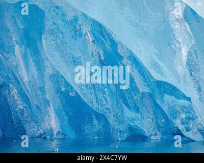 Iceberg in the fjord with melt structure. Landscape in the Johan Petersen Fjord, a branch of the Sermilik Icefjord, Ammassalik region, Greenland, Danish Territory. Stock Photo