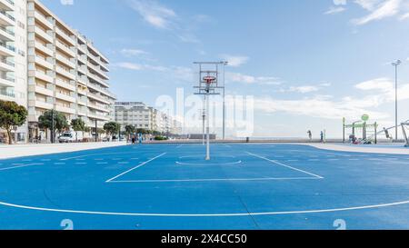 Povoa de Varzim, Porto, Portugal - October 22, 2020: basketball court and children's play park by the sea on an autumn day Stock Photo