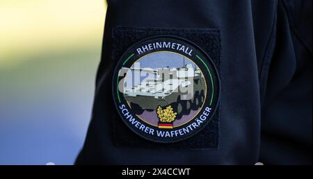 02 May 2024, Lower Saxony, Unterlüß: 'Rheinmetall, Heavy Weapons Carrier' is written on the badge of an employee. The Rheinmetall armaments group has been commissioned to supply the 123 Boxer vehicles with 123 Boxer vehicles with 30mm machine guns. Photo: Philipp Schulze/dpa Stock Photo