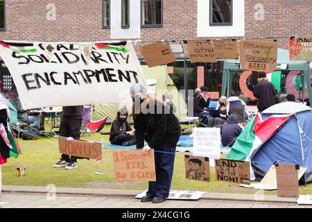 A student adjusts a sign at an encampment on the grounds of Newcastle University, protesting against the war in Gaza. Students in the UK, including in Leeds, Newcastle and Bristol, have set up tents outside university buildings, replicating the nationwide campus demonstrations began in the US last month. Picture date: Thursday May 2, 2024. Stock Photo