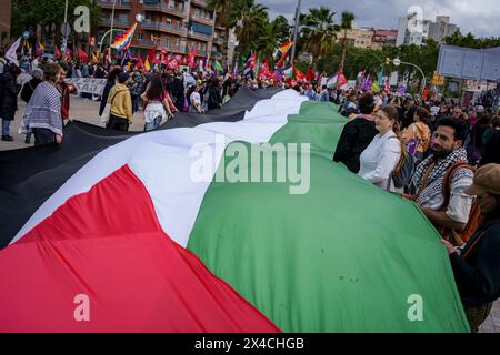 Barcelona, Spain. 01st May, 2024. Protesters hold a huge Palestinian flag during the demonstration. Thousands of people marched in Barcelona and Spain's main cities demanding better wages and working conditions on International Workers Day. (Photo by Davide Bonaldo/SOPA Images/Sipa USA) Credit: Sipa USA/Alamy Live News Stock Photo