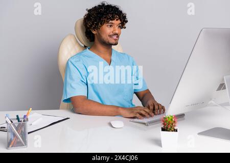 Photo of doctor guy sit table using computer for consultation isolated grey color background Stock Photo