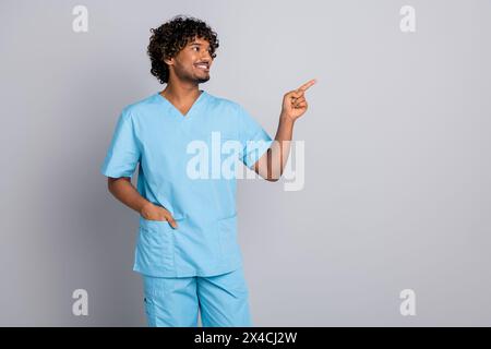 Photo of doctor guy point finger look empty space isolated grey color background Stock Photo