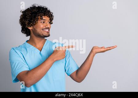 Photo of doctor man hold hand point finger empty space product isolated grey color background Stock Photo