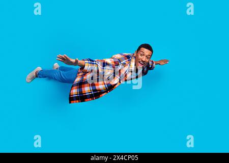 Full length photo of nice young man arms wings flying empty space wear shirt isolated on blue color background Stock Photo