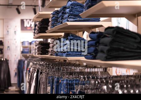 Colorful jeans in the store. Background theme of the trade sale. Clothes on a hanger in the store Stock Photo