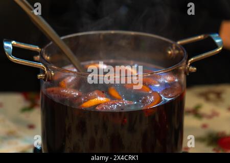 Close-up of a large glass pan with hot spicy mulled wine made from fruits and berries at an outdoor fair and festival Stock Photo