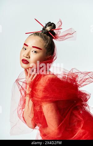 Asian woman in red dress and veil posing gracefully. Stock Photo