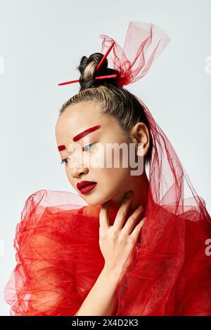 Asian woman in red dress strikes a captivating pose. Stock Photo