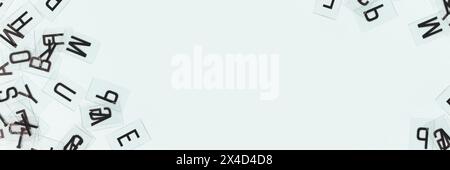 Transparent plastic cards with letters scattered on a blue background. Banner with copy space. Stock Photo
