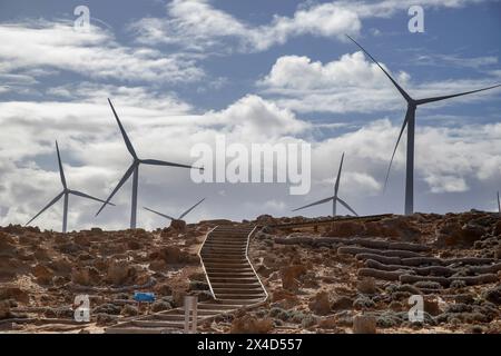 Wind turbines against the backdrop of a natural rad rocky landscape,  stairs and sky. Petrified Forest, located on the sea coast of Cape Bridgewater, Stock Photo