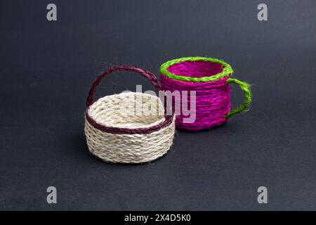 a pair of empty jute products. bucket and cup on black background. Stock Photo