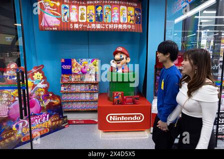 Osaka, Japan. 16th Apr, 2024. A couple walks past a Nintendo display with Super Mario and Princess Peach in a shoppin mall in Osaka on April 16, 2024. - 20240416 PD19467 Credit: APA-PictureDesk/Alamy Live News Stock Photo