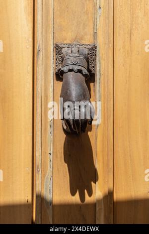 Aigues-Mortes, Gard, Occitania, France. Old metal door knocker in the shape of a hand. Stock Photo