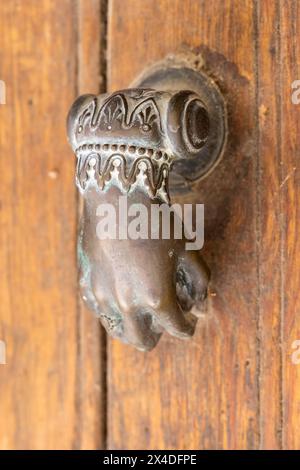 Arles, Bouches-du-Rhone, Provence-Alpes-Cote d'Azur, France. An old brass door knocker in the shape of a hand. Stock Photo