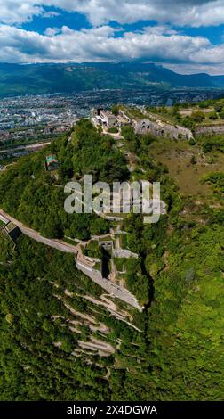 Aerial view of Grenoble's Bastille fort, city skyline crossed by the river and surrounded by mountains. France Stock Photo