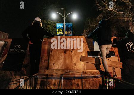 Pro-Palestinian protesters look on at area police forces from the encampment built in front of Royce Hall at UCLA. Stock Photo