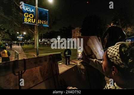 Pro-Palestinian protesters look on at area police forces from the encampment built in front of Royce Hall at UCLA. Stock Photo