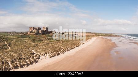 BAMBURGH CASTLE, NORTHUMBERLAND, UK - APRIL 23, 2024.  Aerial landscape panorama view of Bamburgh castle and sand dunes on the beautiful Northumberlan Stock Photo