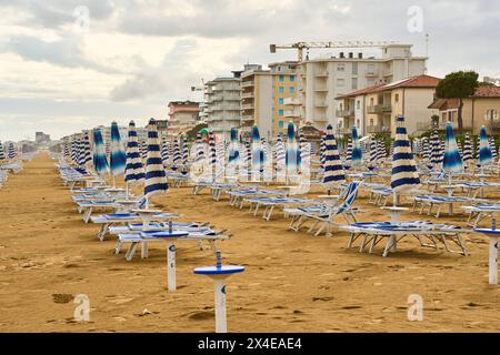 Lido di Jesolo, Italy - 2 May 2024: Closed umbrellas on the beach of Lido di Jesolo in Italy *** Geschlossene Sonnenschirme am Strand von Lido di Jesolo in Italien Stock Photo