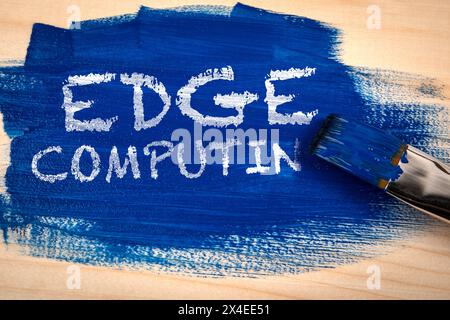 Edge Computing Concept. Blue paint and paint brush on wooden texture background. Stock Photo