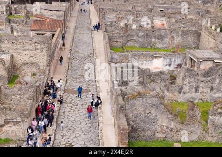 Pompeii tourists - a view of people from above walking along one of the many ruined roads; Pompeii UNESCO World Heritage site; Pompeii tourism, Italy Stock Photo