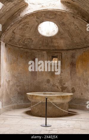 Pompeii thermal baths, or public baths interior; cold water fountain or basin in the hot room, Forum baths, Pompeii ruins, Italy. Roman Civilization Stock Photo