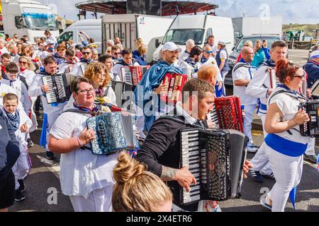 Blue Ribbon accordion players parade along the street for the 'Obby 'Oss festival, an annual folk event on May Day in Padstow, Cornwall, England Stock Photo