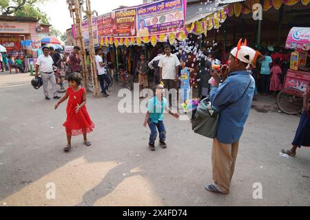 Joyful children dance while a street vendor blows soap bubbles. Bainan Bazaar area, Bagnan, Howrah, West Bengal, India. Stock Photo