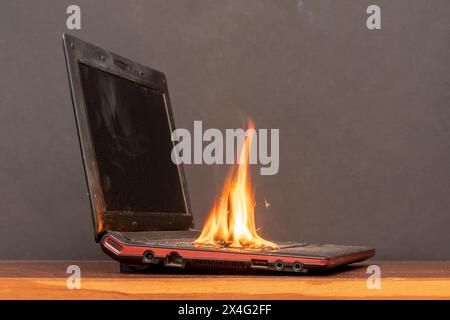 In the room on the table the laptop caught fire, the ignition of the battery and contacts, a short circuit. Fire safety system. Stock Photo