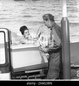 Esso gas station in 1963. The company Svenska Esso was a brand in Sweden between the years 1939 to 1987, when the stations changed their name to the name of the new owner, Statoil. At the gas station, a commercial is being filmed where a motorboat stands by the gas pumps with a young woman seen at the steering wheel. Kristoffersson ref DC135-10 Stock Photo